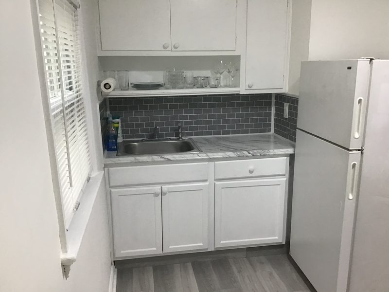 Kitchen with a refrigerator, sink and white cabinets